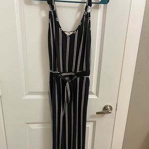 Black and white vertical stripe jumpsuit. Flare legs, tie around waist. Size S.